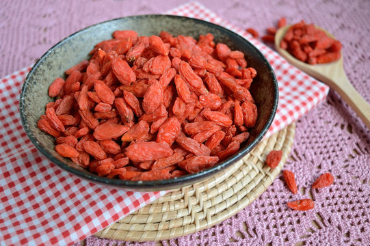Dry Goji berries in a bowl on wooden table, healthy food