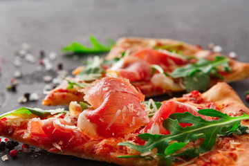 Pizza with prosciutto and rocket salad copy space