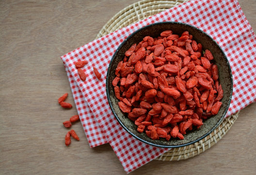 Dry Goji berries in a bowl on wooden table, healthy food