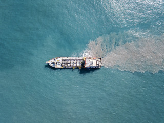 Suction Dredger ship working near the port - with mud, Pollution, brown Muddy water - aerial tip...
