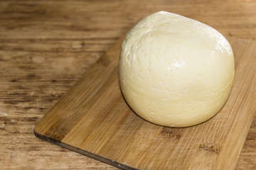 head of cheese gouda sliced piece on a wooden background