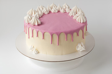 Birthday pink cake for girl, decorated with meringue cookies on a white background.