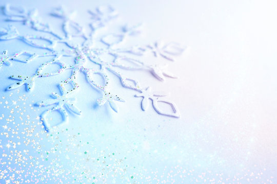 Light blue white Christmas and New Year background. Snowflake in sequins close-up macro with a soft focus. Delicate elegant artistic template for greeting text for the Christmas holidays.