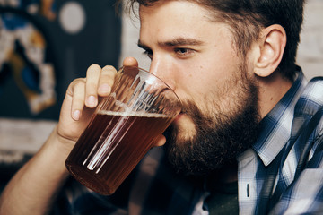 a man with a beard drinks beer, a portrait