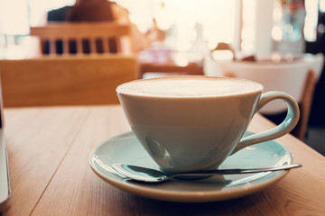 Cup of coffe on workplace desk, coffee shop.