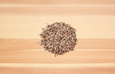 Mixed red, white and black quinoa on wood