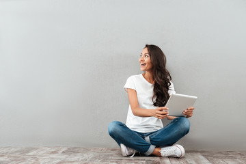 Happy pretty asian woman holding tablet computer