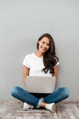 Happy young asian woman working on laptop computer
