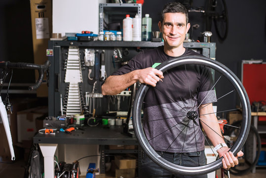Male technician holding a bike wheel