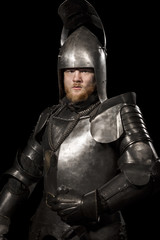Knight in armour after battle on the black background