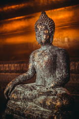 Fototapeta premium Stone statue of Buddha sitting in lotus pose gold-plated. Thailand, religious temple attraction