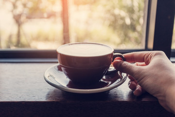 Hand holding coffee cup.