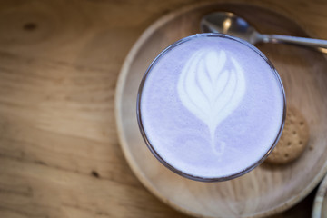 Matcha green tea latte art on wooden table.