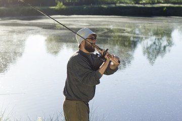 Wędkarz łowi ryby na spinning. Zarzuca przynętę. © Tomasz