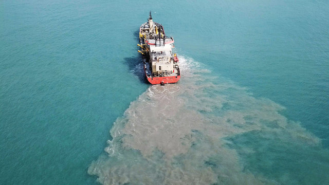 Suction Dredger ship working near the port - with mud, Pollution, brown Muddy water - aerial shot