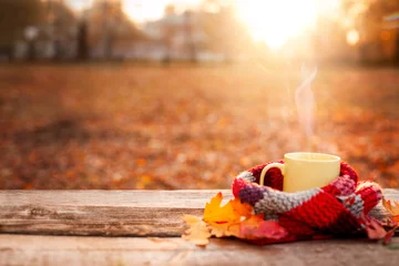 Foto op Plexiglas Tea mug covered with warm scarf on wooden surface © Cherries