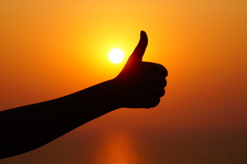 Thumb up, cool gesture, hand sign, silhouette of a hand on the sunset