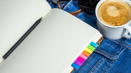 Blank notebook and coffee on the jean shirt.