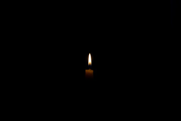 Small candle burning in the dark