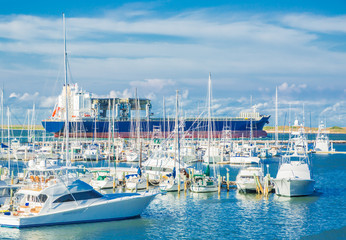 Ship Leaving Port / A large tanker ship passing a marina filled with pleasure and fishing boats on it's way to sea. © Terry Walsh Photo