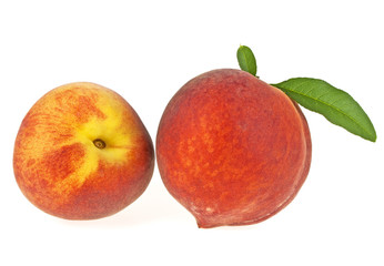 Two peach fruits with leaf isolated on a white background