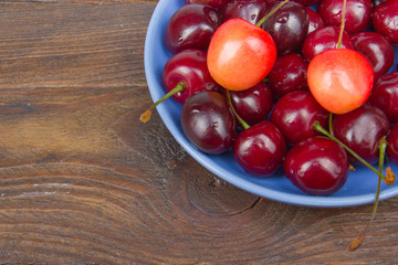 Various summer Fresh Cherry in a bowl on rustic wooden table. Antioxidants, detox diet, organic fruits. Berries
