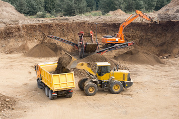 Loading in gravel quarry - Wheel loader loads transport