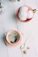coffee and marshmallows on wooden background composition with flowers