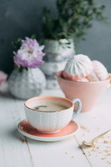 coffee and marshmallows on wooden background composition with flowers