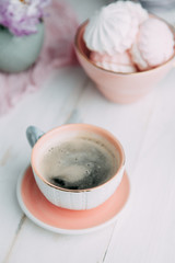 coffee and marshmallows on wooden background composition with flowers