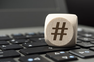 Holzwürfel mit Tastatur Laptop und Hashtag Raute
