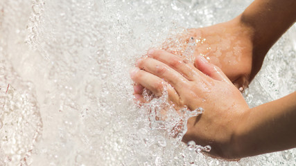 Hands of a boy with a splash of water.