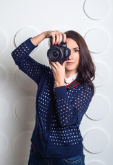 studio portrait of young woman taking picture over white