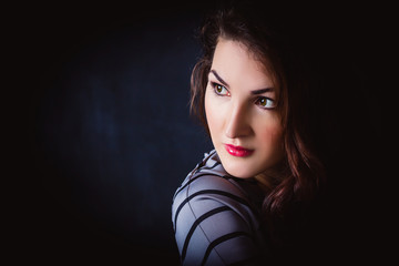 Portrait of young beautiful woman with stylish make-up on black background. business concept