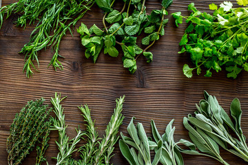 drying fresh herbs and greenery for spice food on wooden kitchen desk background top view