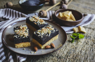 Sponge cake with poppy seed layer, decorated with white chocolate curls and sliced almond