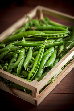 Peas closeup group in wooden box on dark wooden table in studio