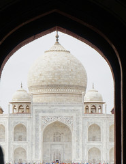 Fototapeta na wymiar The famous monument of Taj Mahal as seen through the arched entry gate. This is a landmark and a popular tourist destination