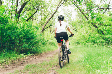 Naklejka premium Woman riding a mountain bike in the forest