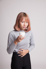 Asian woman drinking a glass of milk got stomachache.