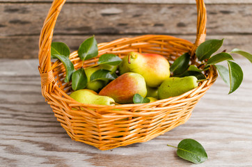 Pears in basket on wooden background