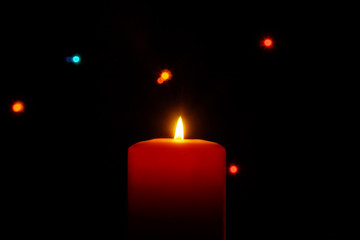 Closeup of burning candle isolated on black background