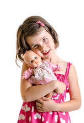 Sweet little girl in pink dress hug baby toy smiling isolated