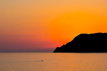 Fototapeta premium Natural Sunset, Sunrise over sea, mountain Bright Dramatic Sky And Dark Ground. Countryside Landscape Under Scenic Colorful Sky At Sunset Dawn Sunrise. Sun Over Skyline, Horizon. Warm Colours.