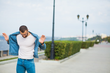 Handsome athletic fit man in jeans wear fitness model outdoors