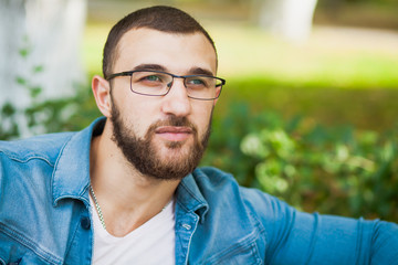 Fototapeta premium Handsome young man in glasses with beard relax outdoors