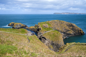 Ballintoy, United Kingdom - May 2, 2016: Carrick-a-Rede Rope Bridge, a popular tourist destination in Northern Ireland. Tourists passing the bridge.