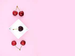 Ripe sweet cherries on pink background.