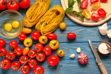 Ingredients for cooking pasta on a wooden table.
