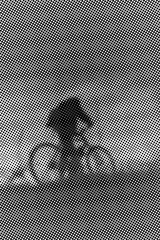 Man with bicycle at sunset - monochrome halftone pattern background